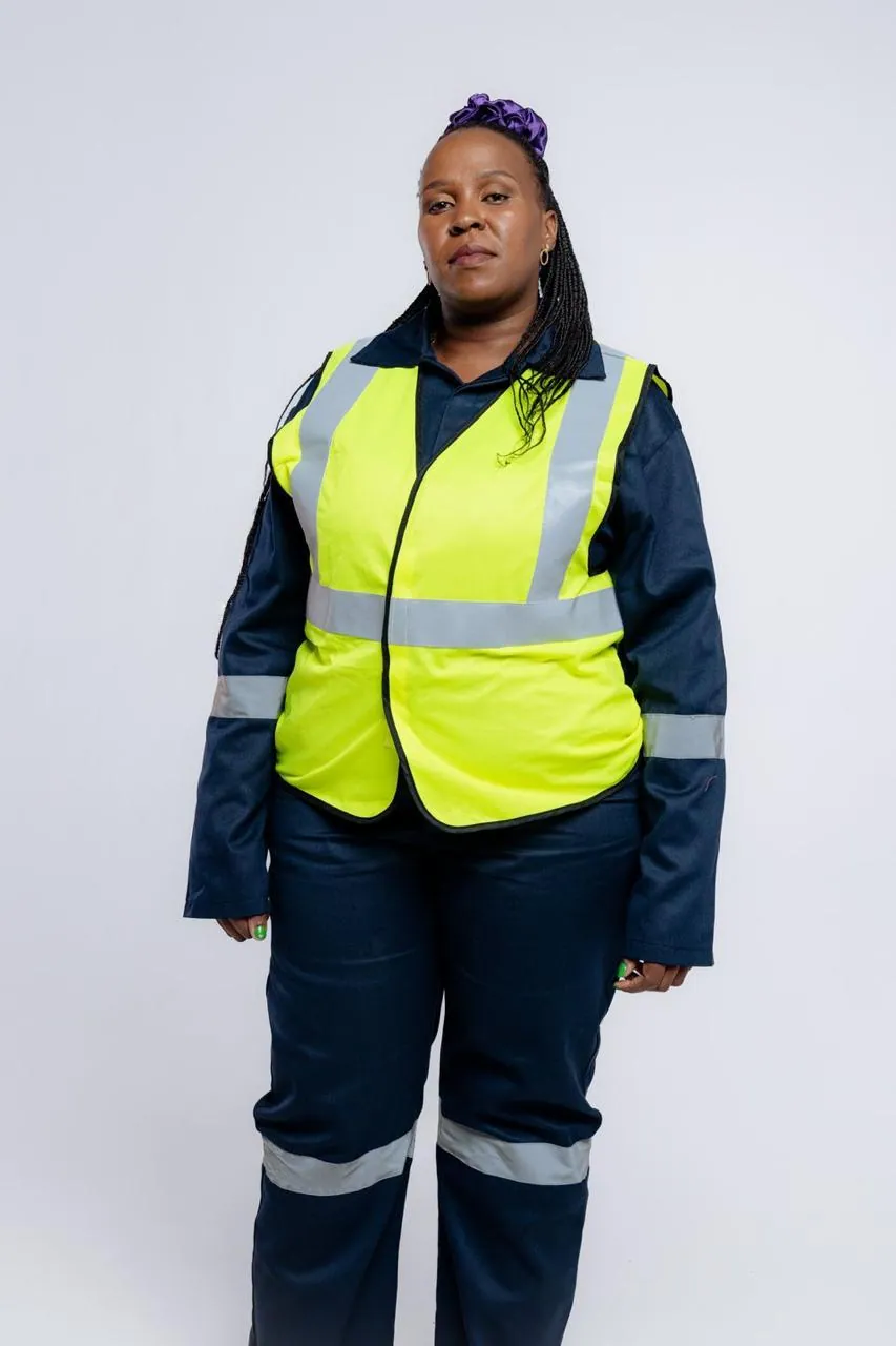 Worker in a yellow high-visibility reflective vest over navy workwear