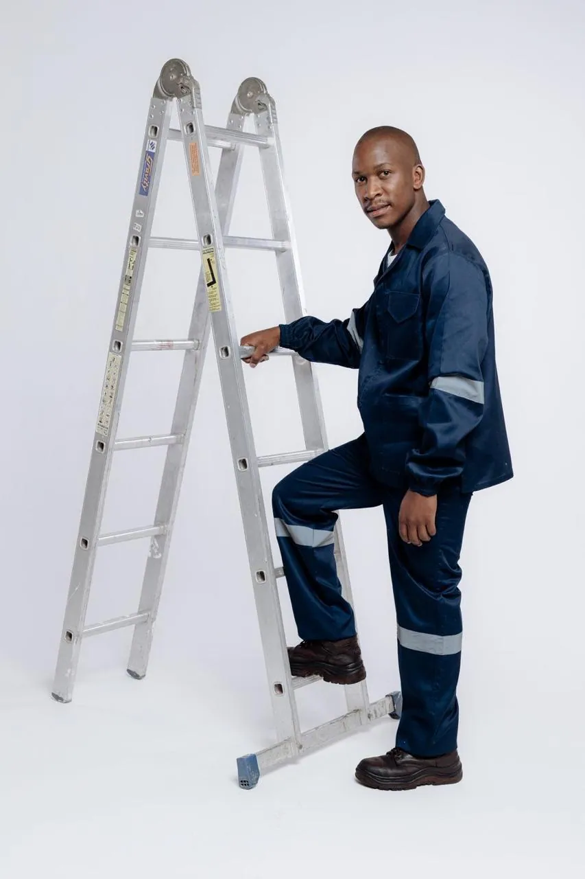 Worker in navy workwear with reflective trim, on site