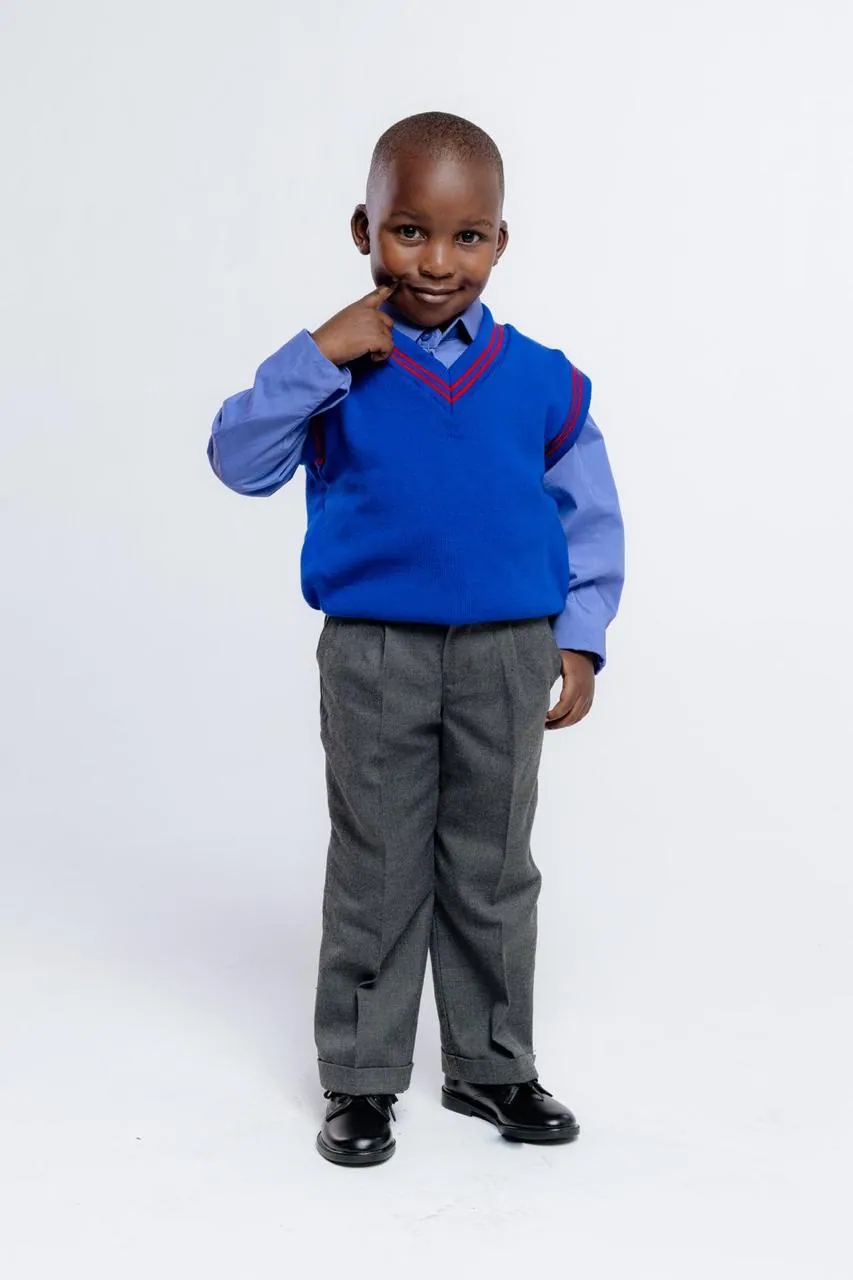Learner in a full school uniform: jersey, shirt, tie and trousers